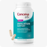Conceive Plus Ovulation Support (ES) bottle with 120 vegetarian capsules for female ovulation health, shown with a teal label. Image features a white supplement bottle and two beige capsules placed nearby on a light background.